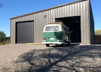 two door straight-walled garage for sale with van in front.