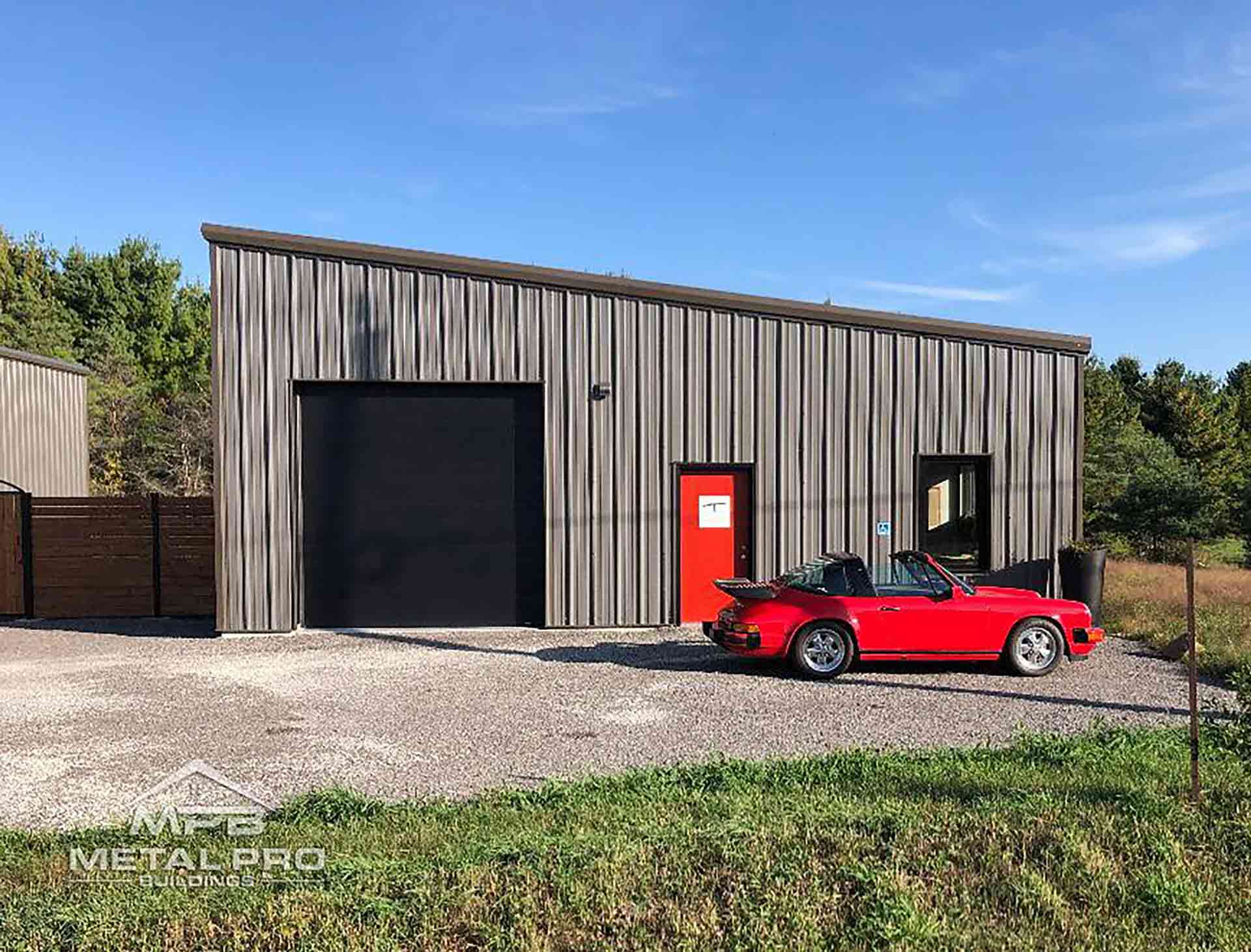 exterior of a prefabricated steel buildings with a red classic car parked