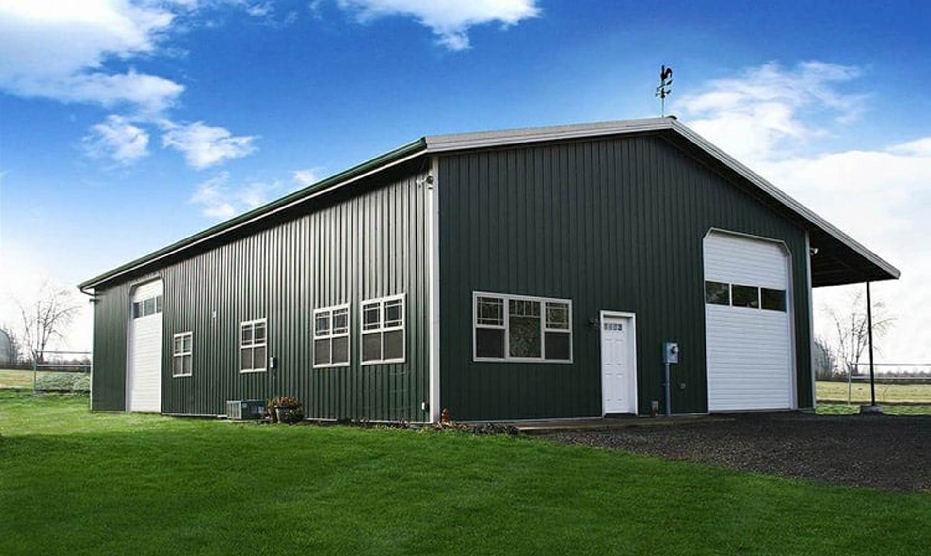 exterior of a rigid steel building with two garage doors and a service door