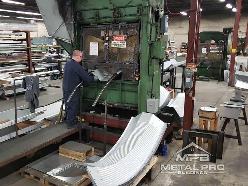 worker at a steel building factory operating an equipment