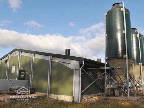 exterior of agricultural steel building painted green with fermented feed storage