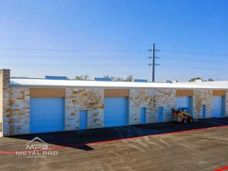 exterior of industrial steel building with brick finish and four garage door openings