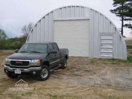 quonset hut garage building with white garage door and steel entry door