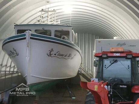 interior of a quonset hut storage building with a boat and tractor inside