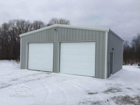 grey straight wall garage building with two white garage doors