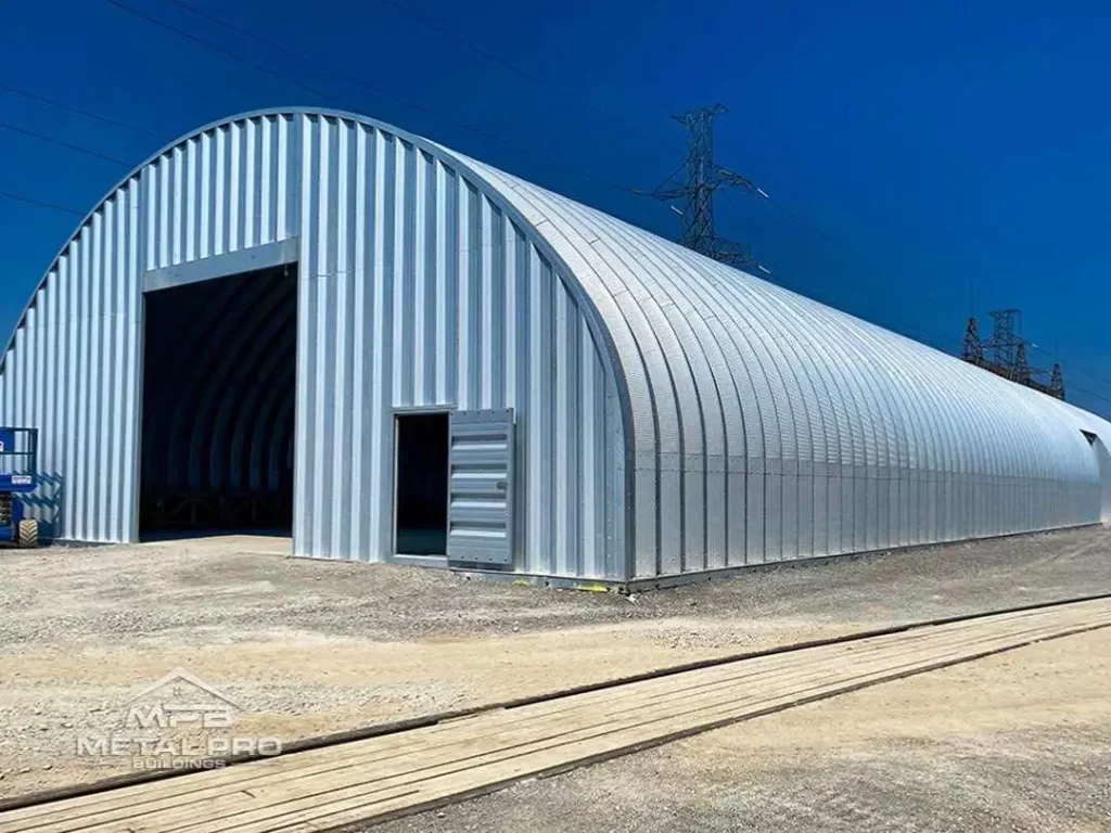 quonset hut steel warehouse building with garage door opening and entry door