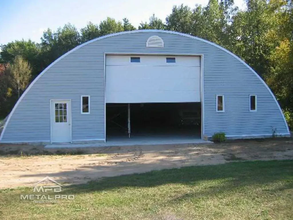 quonset hut workshop building with a white garage door and entry door