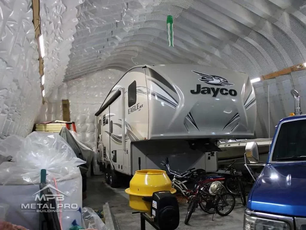 interior of a quonset hut storage building with a RV and truck