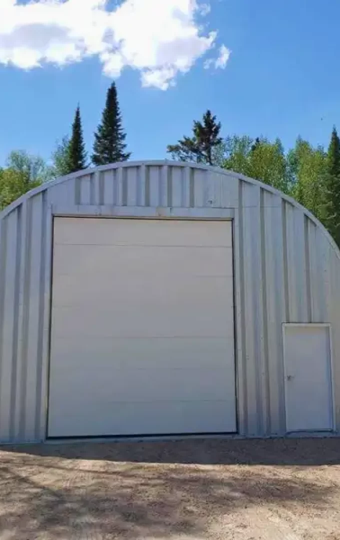 quonset hut building, steel endwall finish , with white garage and entry door